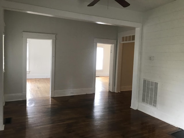 empty room with ceiling fan and dark hardwood / wood-style floors