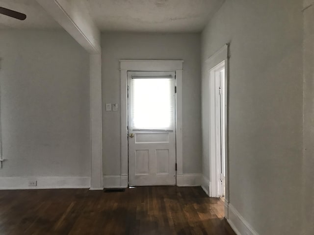 doorway featuring ceiling fan and dark hardwood / wood-style flooring