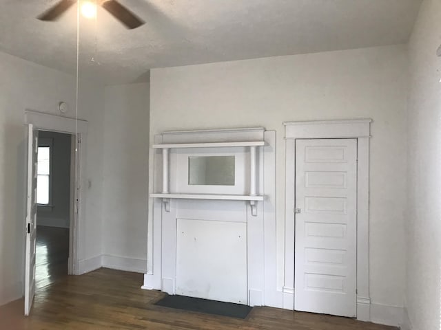 interior space with ceiling fan and dark wood-type flooring