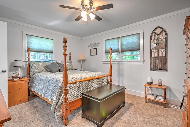 carpeted bedroom with ornamental molding, baseboards, and a ceiling fan