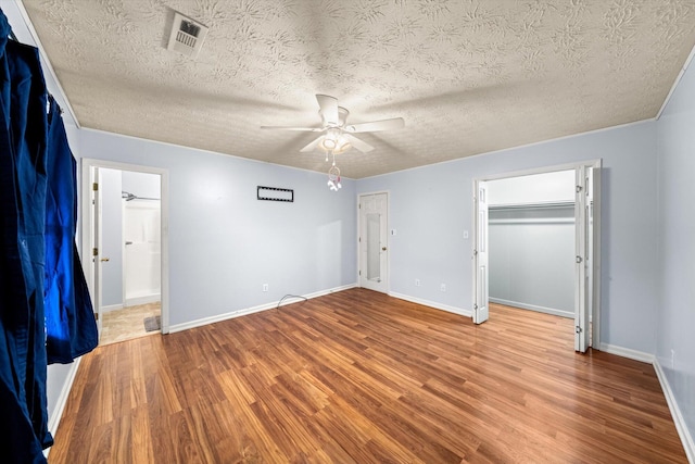 unfurnished bedroom featuring hardwood / wood-style floors, a textured ceiling, and ceiling fan