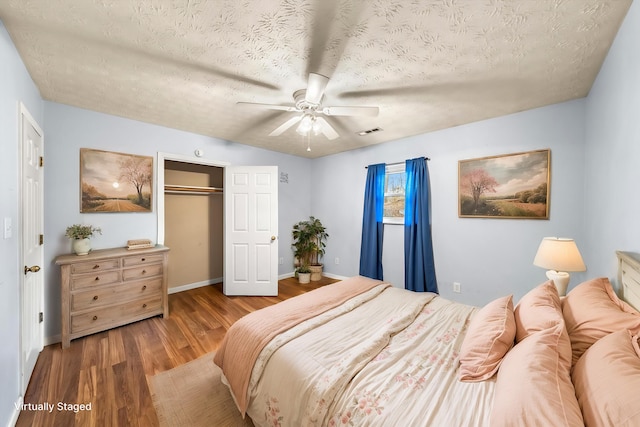 unfurnished room featuring ceiling fan, hardwood / wood-style floors, and a textured ceiling