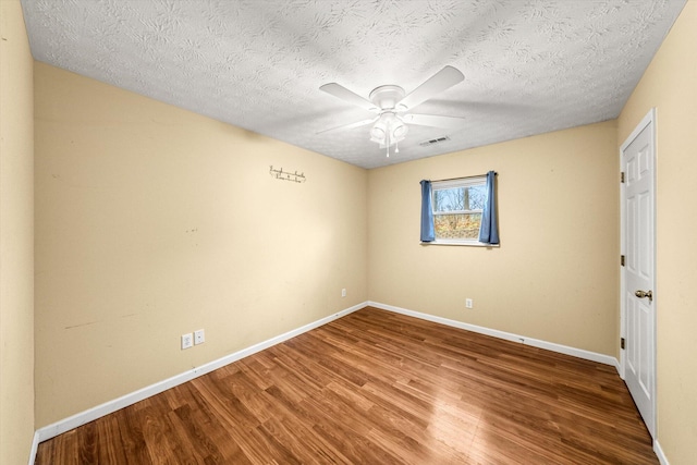 empty room featuring ceiling fan, wood-type flooring, and a textured ceiling