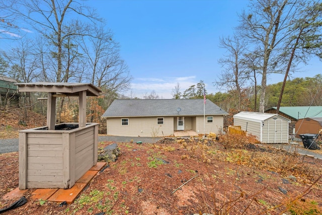 back of house with a storage unit