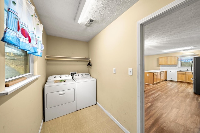 laundry area with a textured ceiling and independent washer and dryer