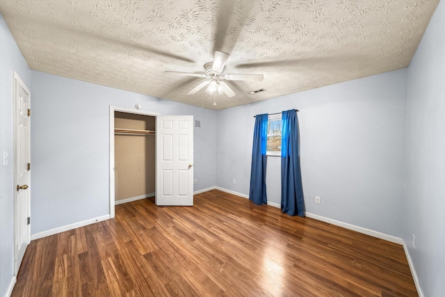 unfurnished bedroom with a textured ceiling, wood-type flooring, a closet, and ceiling fan