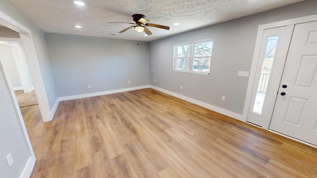 entrance foyer with a textured ceiling, light wood-style floors, recessed lighting, and baseboards