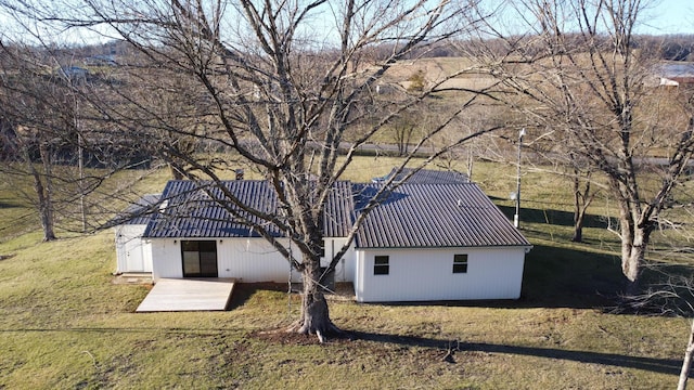 exterior space featuring a front yard and metal roof