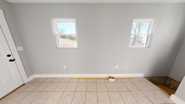 empty room with a wealth of natural light and baseboards