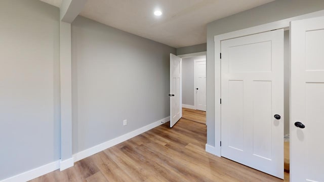 unfurnished bedroom featuring light wood-type flooring, baseboards, and recessed lighting