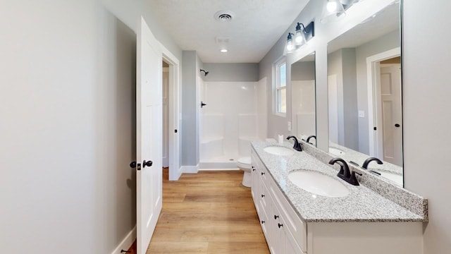 bathroom with double vanity, a sink, visible vents, and a shower stall