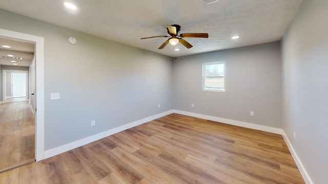 spare room featuring light wood-type flooring, ceiling fan, baseboards, and recessed lighting