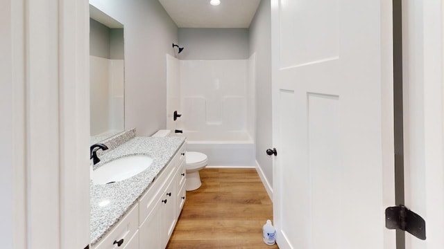 full bathroom with toilet, shower / bathing tub combination, wood finished floors, and vanity