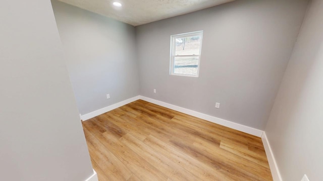 empty room with light wood-style floors and baseboards