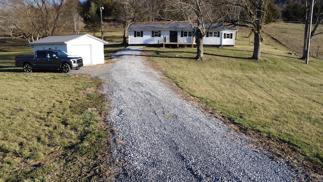 view of front of property with an outbuilding, gravel driveway, and a front lawn