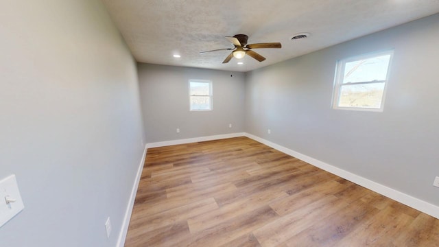 empty room featuring visible vents, baseboards, and wood finished floors