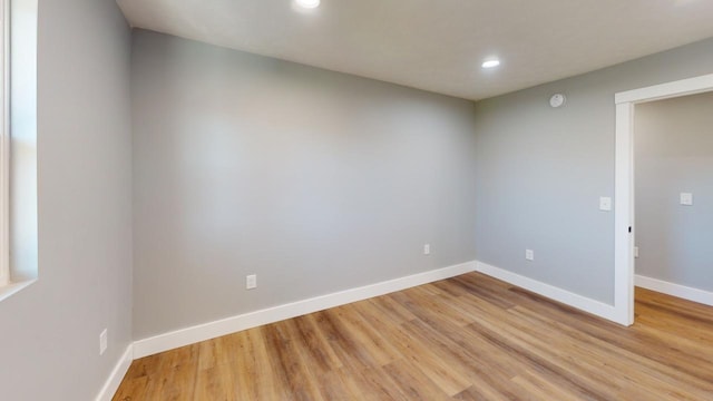 empty room with light wood-style floors, baseboards, and recessed lighting