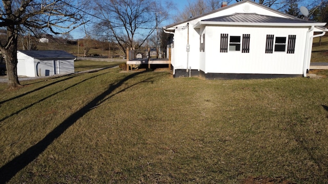 view of side of property with metal roof and a yard