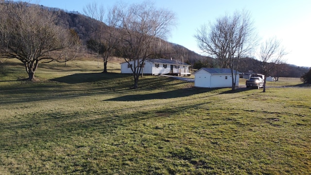 view of yard with an outbuilding and a rural view