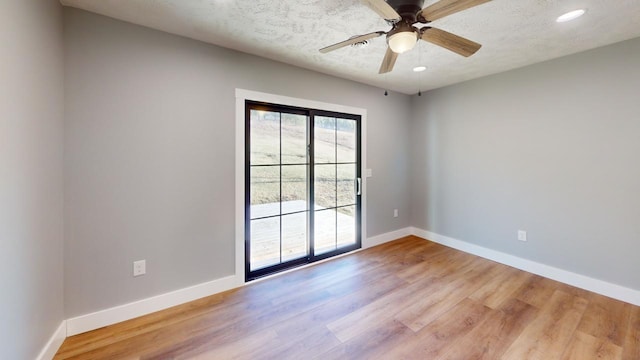 spare room featuring ceiling fan, a textured ceiling, baseboards, and wood finished floors