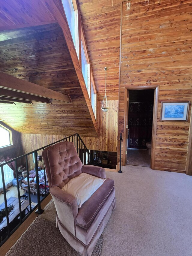living area with wooden walls, carpet floors, high vaulted ceiling, and wood ceiling