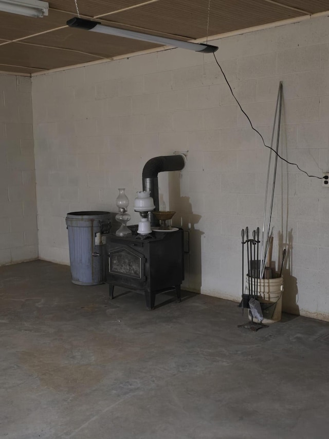 below grade area with a wood stove and concrete block wall