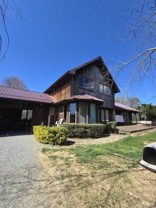 view of front of property with a carport, metal roof, and gravel driveway
