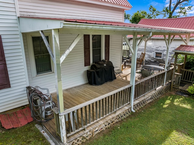 wooden deck with a lawn and a grill