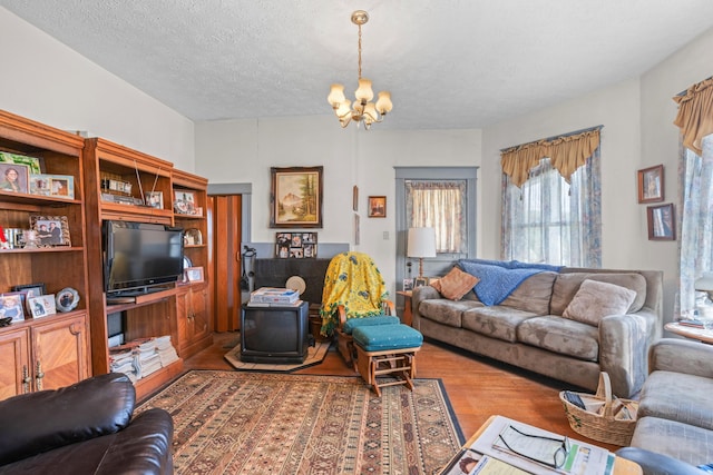 living room featuring hardwood / wood-style flooring, a textured ceiling, and a chandelier
