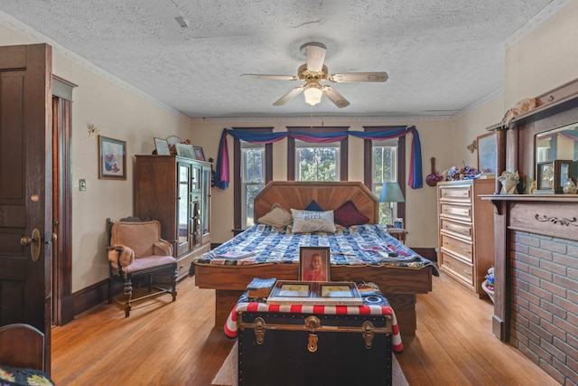 bedroom featuring ceiling fan, light hardwood / wood-style flooring, and a textured ceiling