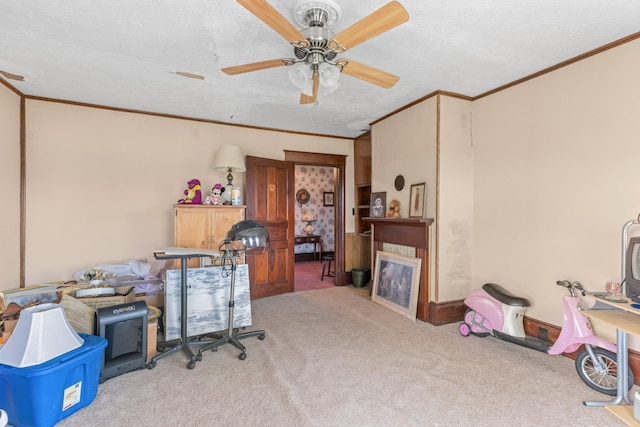 carpeted home office with a textured ceiling, ceiling fan, and ornamental molding