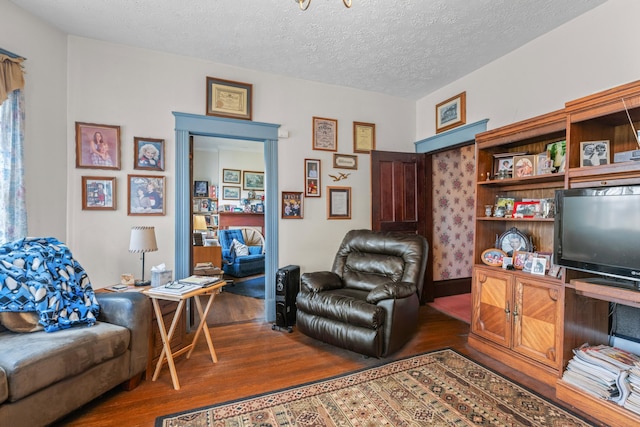 living room featuring a textured ceiling and dark hardwood / wood-style flooring