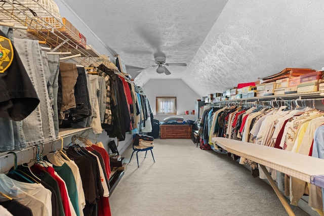 spacious closet with ceiling fan, carpet, and lofted ceiling