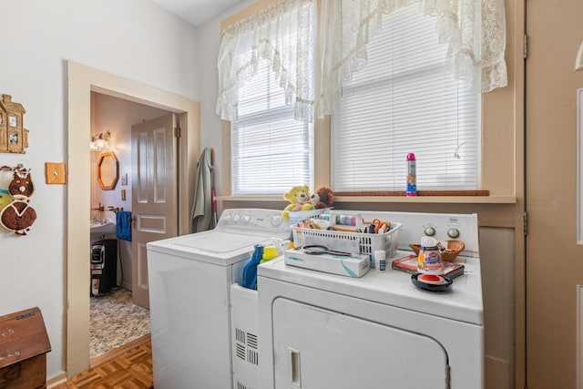 laundry area featuring washer and clothes dryer and parquet flooring
