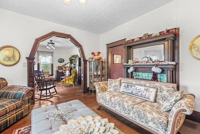 living room with a textured ceiling and dark wood-type flooring
