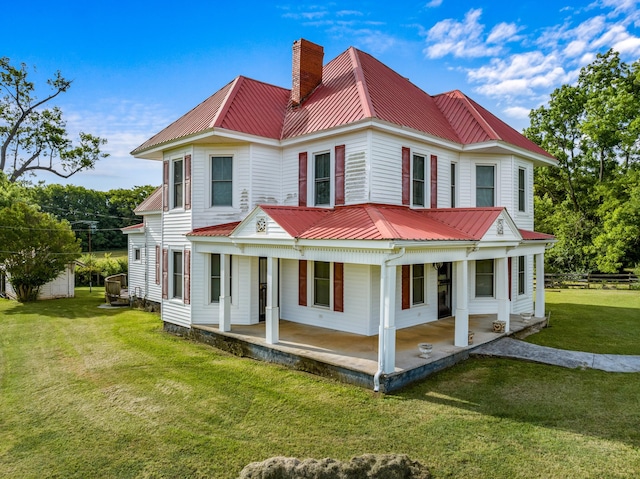 back of property featuring a lawn and covered porch