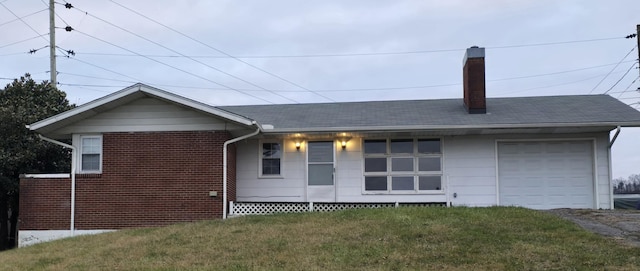 back of house with a lawn and a garage