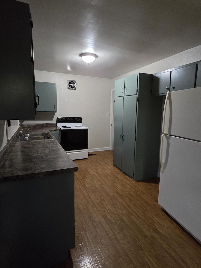 kitchen featuring white appliances, dark wood-type flooring, and sink