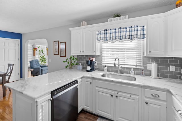 kitchen with sink, black dishwasher, dark hardwood / wood-style floors, kitchen peninsula, and white cabinets