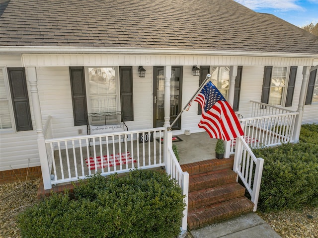 view of exterior entry featuring covered porch