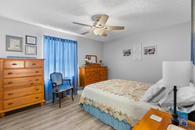 bedroom featuring ceiling fan, a textured ceiling, and hardwood / wood-style floors