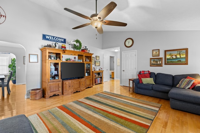 living room featuring hardwood / wood-style flooring, high vaulted ceiling, and ceiling fan