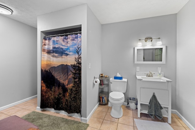 bathroom with tile patterned flooring, vanity, toilet, and a textured ceiling