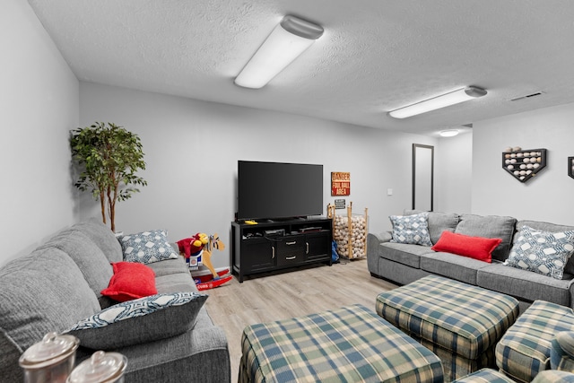 living room featuring light hardwood / wood-style flooring and a textured ceiling