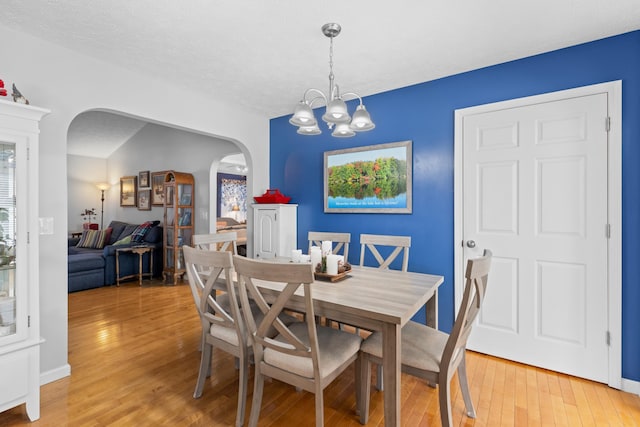 dining space featuring an inviting chandelier and light hardwood / wood-style flooring