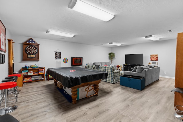 rec room with billiards, a textured ceiling, and light hardwood / wood-style floors