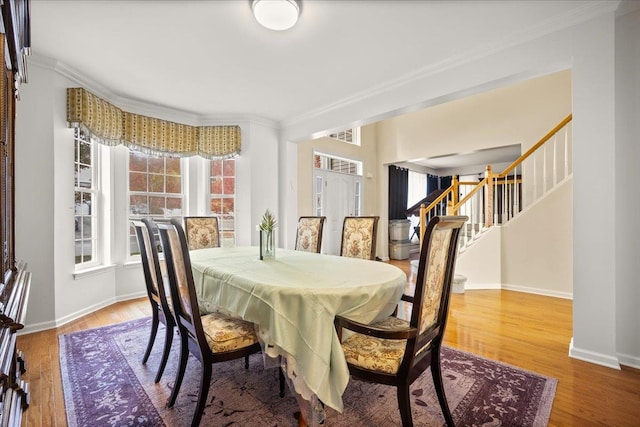 dining area with hardwood / wood-style floors and crown molding