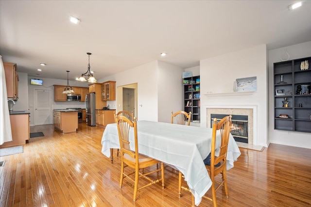 dining room with a premium fireplace and light hardwood / wood-style floors