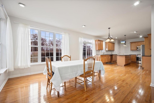 dining room with light hardwood / wood-style floors and sink