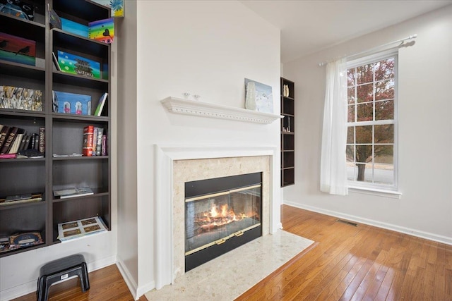 living room with hardwood / wood-style flooring and a high end fireplace